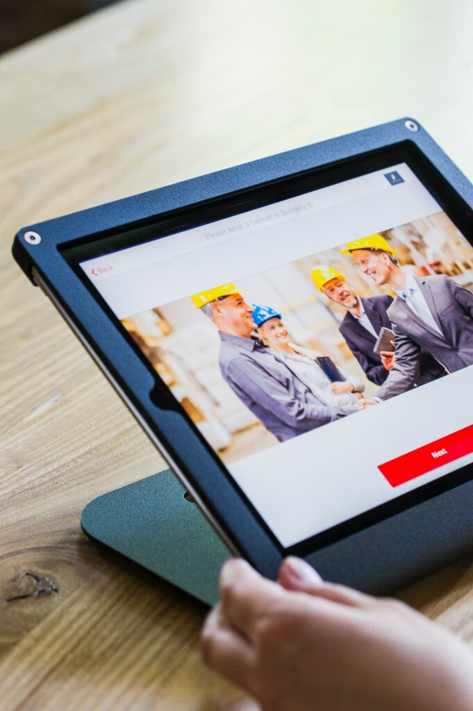 Un tablet che visualizza un gruppo di lavoratori con caschetti gialli per la sicurezza sul lavoro