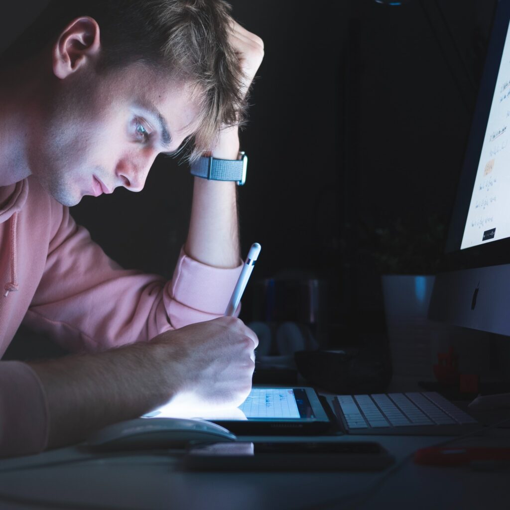 Uomo che lavora al tablet di notte e al buio