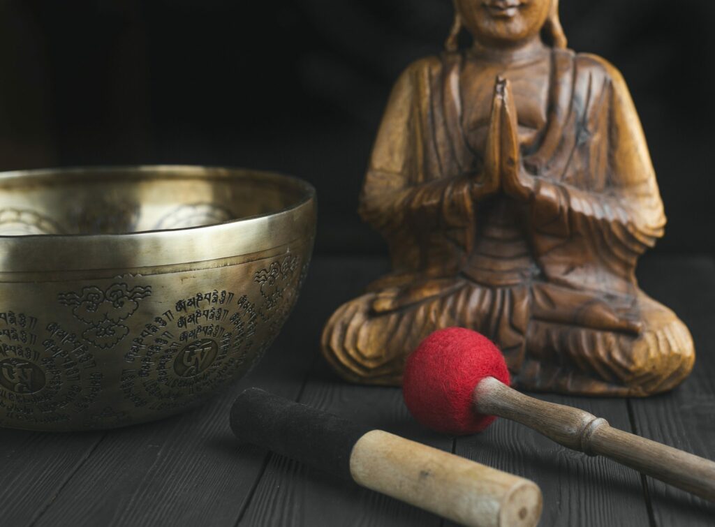 Statuina di Buddha accanto a uno strumento musicale a percussione
