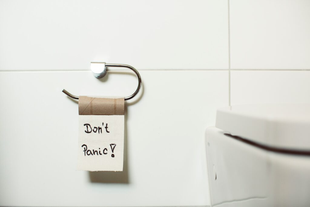 Cartoncino di un rotolo di carta igienica con un solo strappo attaccato che riporta la scritta "Don't panic"